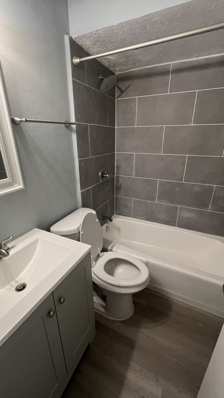 a bathroom with a toilet, sink and shower at The Hampton Gardens